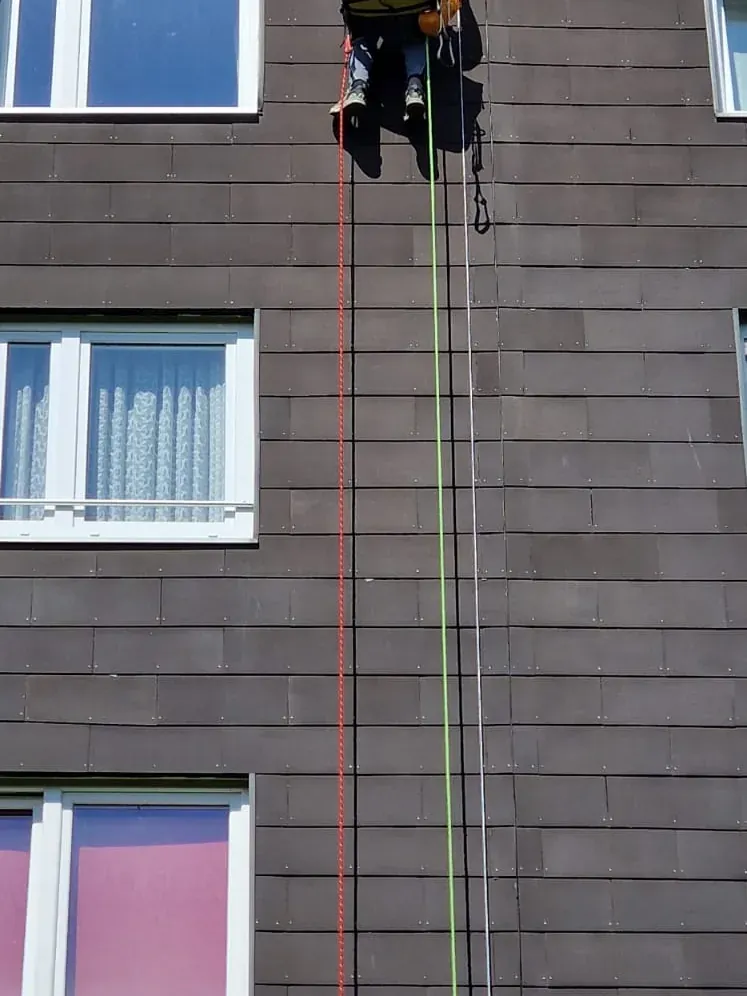 Monteur am Seil an einer Fassade